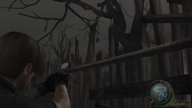 Resident Evil 4 : Leon Kennedy pointe son arme sur un médaillon bleu.