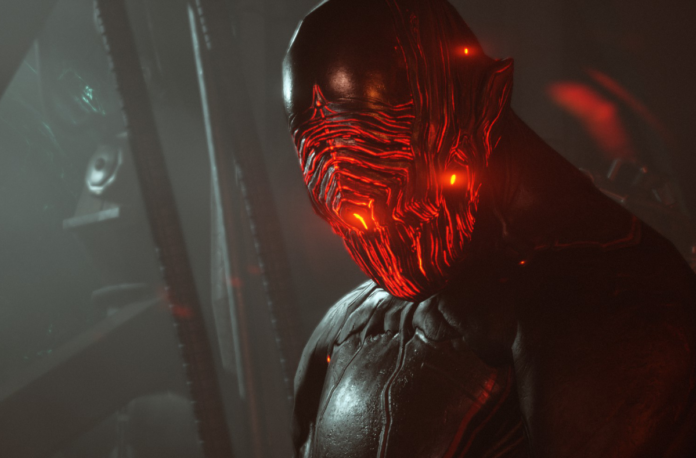 A being with black armour and a glowing red face against a dark sci fi background