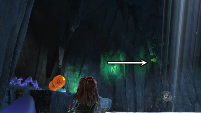 Aloy dans une caverne avec une flèche pointant vers l'emplacement d'un robot.